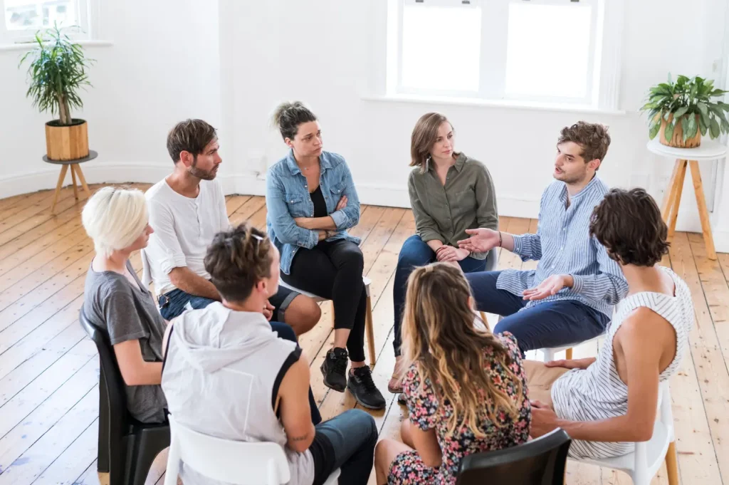 therapy for substance abuse showing an engaged group seated in a circle discussing recovery together