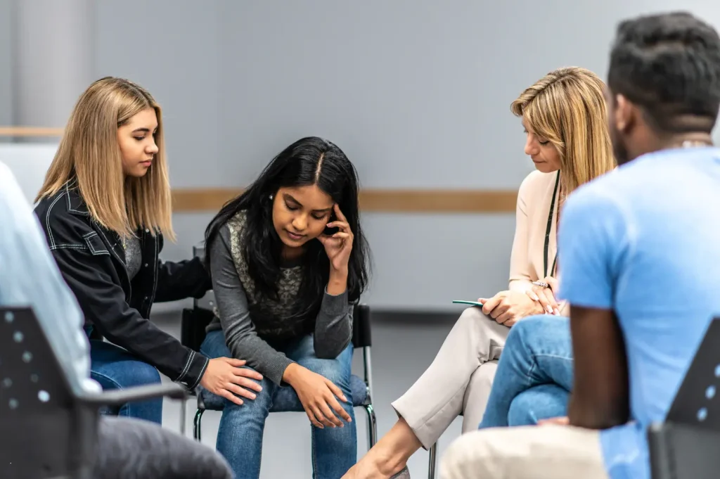 Drug detox centers provide emotional support in group therapy for individuals beginning addiction recovery.