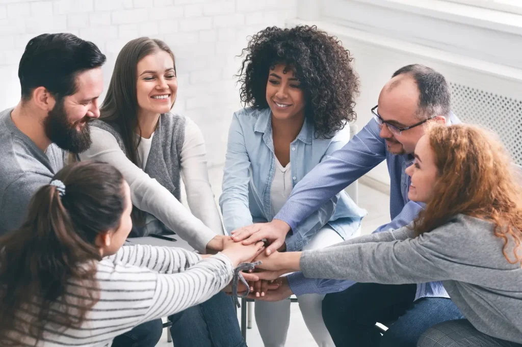 Alcohol detoxification treatment group celebrating shared progress in addiction recovery.