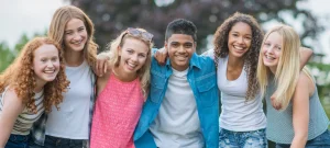 Youth recovery programs smiling teenagers standing together outside showing friendship and positive connection in recovery.
