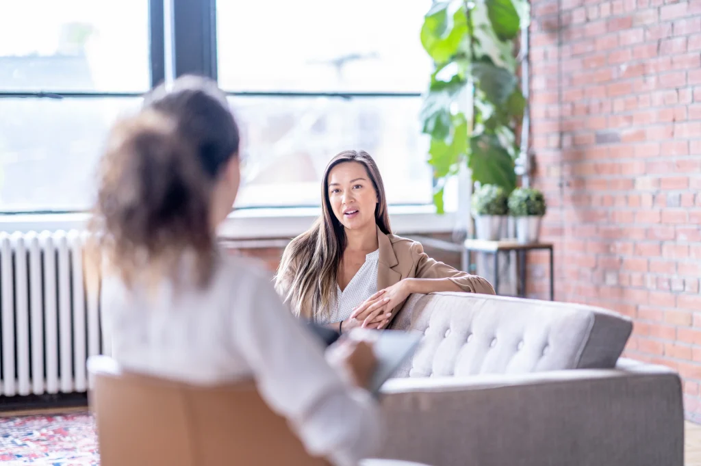 Best rehab programs shown as a therapist speaking with a client during a supportive one-on-one counseling session.