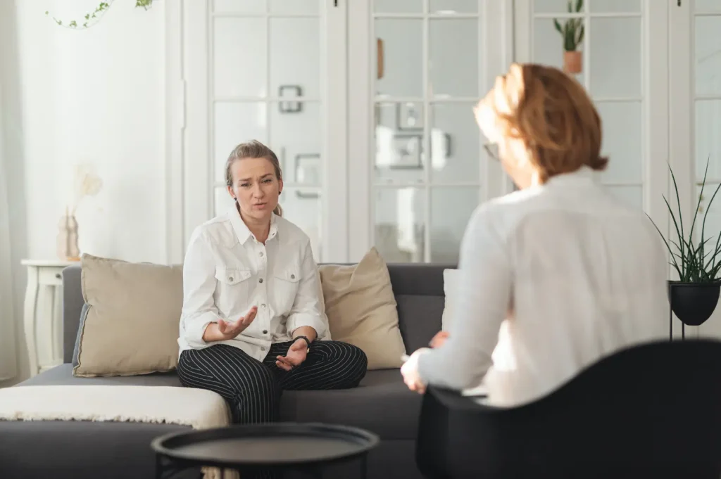 Client and therapist sit face-to-face, discussing trauma and coping.