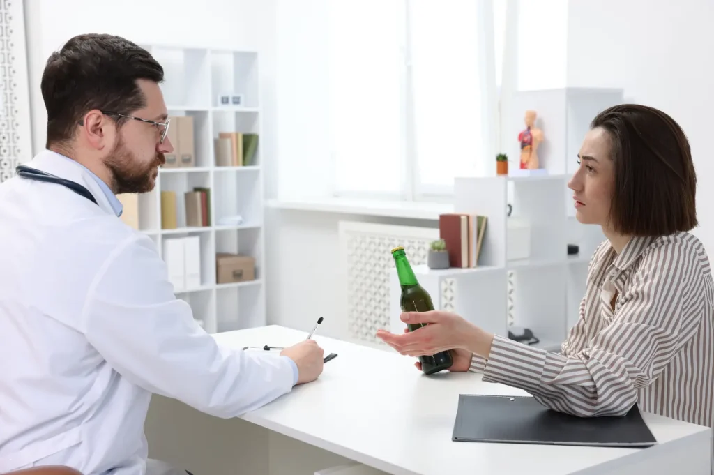 Substance abuse treatment cost discussed during a medical consultation where a patient holds a beer bottle while speaking with a doctor.