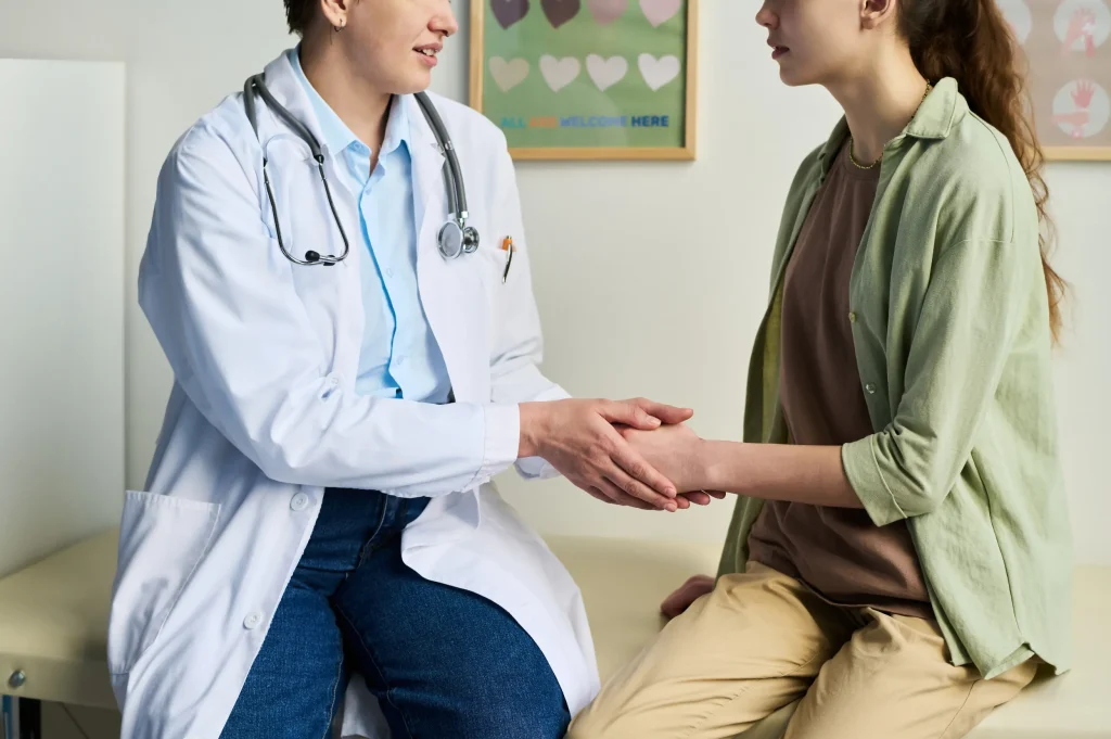 doctor holding patient's hand while discussing medical treatment options in a clinic